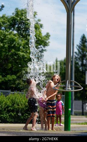 Tre bambini che giocano in giochi d'acqua e fontane a Quebec City, Canada Foto Stock