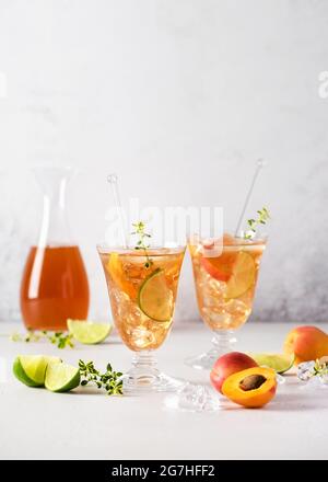 Cocktail di albicocche fresche con ghiaccio, timo di lime e limone in vetro. Cocktail analcolici freschi fatti in casa in estate. Messa a fuoco selettiva. Spazio di copia. Foto Stock