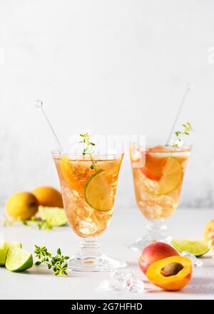 Due bicchieri di cocktail di albicocche fresche con ghiaccio, timo di lime e limone. Cocktail analcolici freschi fatti in casa in estate. Messa a fuoco selettiva. Copia sp Foto Stock