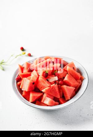 Insalata di frutta estiva con anguria biologica e fragole selvatiche. Concetto di cibo sano e stile di vita. Spazio di copia. Foto Stock