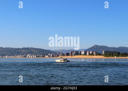 Vista sulla baia da Santona verso Laredo e uno yacht che passa di fronte al nord della Spagna Foto Stock