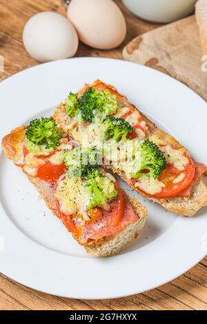 Aprire il panino con prosciutto, mozzarella e pomodori sul tavolo da cucina, fondale focus Foto Stock