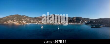 Isola di Sifnos, Platys gialos aereo drone vista panoramica dal mare. Grecia Cicladi. Barche ormeggiate a calmo Mar Egeo, cielo azzurro sfondo. Su Foto Stock