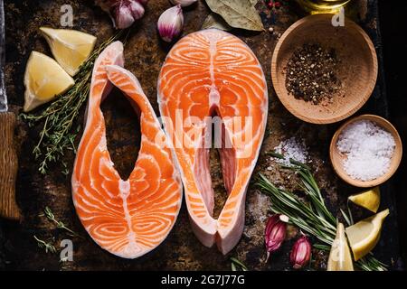 Bistecche di salmone. Fette di salmone fresco con spezie, erbe su vassoio di metallo, vista dall'alto Foto Stock