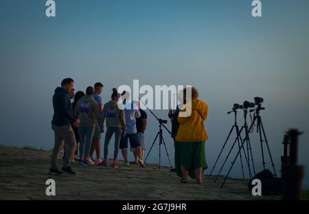 Giovani e fotografi su una vetta di montagna incontrano l'alba - 01 luglio mattina, 2021, Shipka, Bulgaria Foto Stock