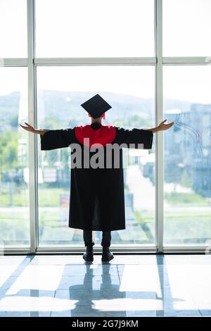 Uomo studente laureato indiano indossando cappello e abito di laurea Foto Stock