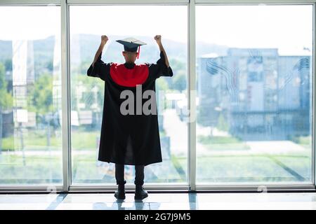 Uomo studente laureato indiano indossando cappello e abito di laurea Foto Stock