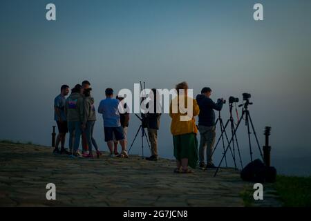 Giovani e fotografi su una vetta di montagna incontrano l'alba - 01 luglio mattina, 2021, Shipka, Bulgaria Foto Stock