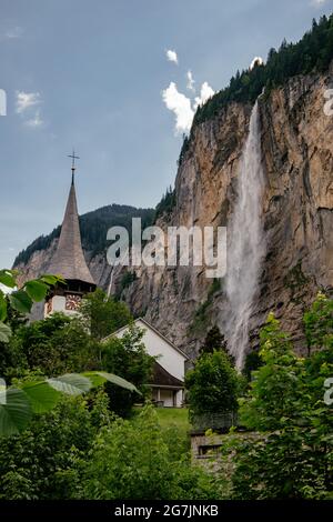 Lauterbrunnen Chiesa con cascata di Staubbachfall - piccolo villaggio - Jungfrau Regione in estate - Alpi svizzere, Svizzera Foto Stock