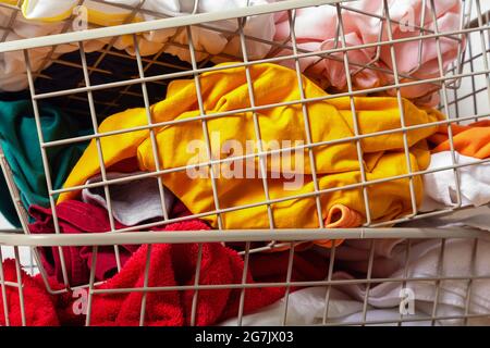 Pile di bucato sporco e colorato in cestini. Foto Stock