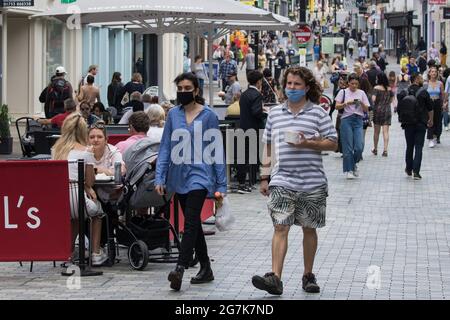 Windsor, Regno Unito. 14 luglio 2021. I residenti e i visitatori locali fanno shopping e si rilassano nel centro della città, con alcuni che scelgono di indossare i rivestimenti per il viso all'aperto. Il governo del Regno Unito ha annunciato il 12 luglio che il 19 luglio l'Inghilterra passerà alla fase finale di alleggerimento delle restrizioni del Covid-19, con la rimozione di quasi tutte le restrizioni legali sui contatti sociali, Ma hanno anche consigliato al pubblico di esercitare cautela dato che l’onda corrente guidata dalla variante Delta non dovrebbe raggiungere il picco fino a metà agosto. Credit: Mark Kerrison/Alamy Live News Foto Stock