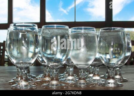 I bicchieri riempiti di acqua ghiacciata sono pronti per i server da portare ai tavoli. Foto Stock