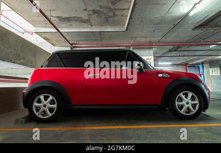 Bangkok, Thailandia - 30 Giu 2021: Vista laterale di Red mini cooper parcheggiato nel parcheggio. Messa a fuoco selettiva. Foto Stock