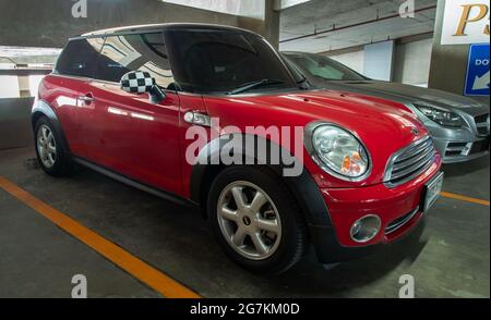 Bangkok, Thailandia - 30 Giu 2021: Vista laterale di Red mini cooper parcheggiato nel parcheggio. Messa a fuoco selettiva. Foto Stock