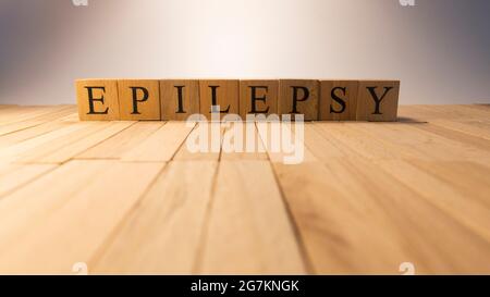 La parola epilessia è stata creata da cubi di legno. Malattia e salute. Primo piano. Foto Stock