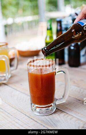 Michelada birra messicana con succo di pomodoro, salsa calda e limone, cocktail messicano in Messico Foto Stock