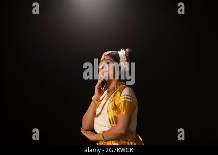 Ballerina Mohiniattam che guarda al cielo nella sua performance di danza Foto Stock