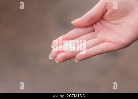 Hailstone su una mano di donne dopo forte tempesta Foto Stock