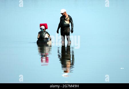 REGIONE DI ODESA, UCRAINA - 14 LUGLIO 2021 - un uomo e una donna sono coperti di fango nella località termale di Kuialnyk, nella regione di Odesa, Ucraina meridionale. Foto Stock