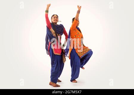 Due ballerini Giddha che eseguono un passo di danza insieme alle mani nell'aria. Foto Stock