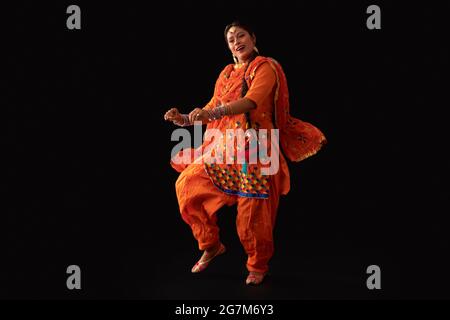 Una donna in costume di Giddha raffigurante un passo di danza. Foto Stock