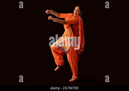 Una donna in costume di Giddha raffigurante un passo di danza con gesti a mano. Foto Stock