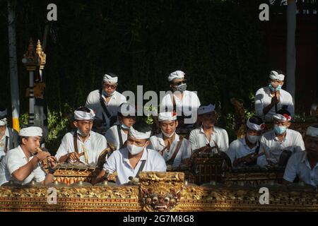 UBUD, BALI-MAGGIO 11 2021: Un gruppo di giovani balinesi che suonano lo strumento musicale balinese Gambelan per accompagnare una cerimonia durante il pandemi COVID-19 Foto Stock