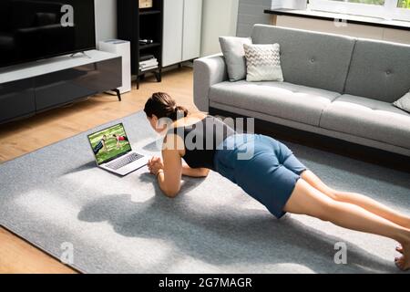 Donna che fa l'allenamento in linea di idoneità a casa Foto Stock