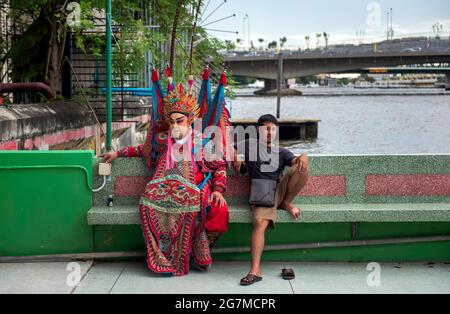 Un membro del Teochew Lao Buan Ni Cung, una troupe itinerante dell'Opera cinese, si prepara a suonare a Thonburi, Bangkok questa sera. Foto Stock