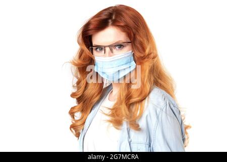 Donna dei capelli rossi di media età che indossa maschera di protezione del coronavirus per il virus epidemico covid-19 sorridente nell'amore facendo il simbolo del cuore forma con le mani. Romanti Foto Stock