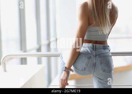 Braccialetto fitness che mette a disposizione della giovane donna vista posteriore Foto Stock