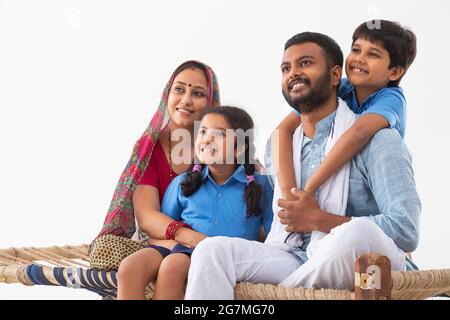 RITRATTO DI UNA FAMIGLIA RURALE FELICE GUARDANDO LONTANO DALLA MACCHINA FOTOGRAFICA E IN POSA Foto Stock