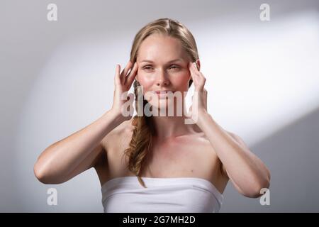 Regime di trattamento di bellezza usando le mani e le dita per massaggiare delicatamente il viso. Calma e relax. Io tempo. Foto Stock