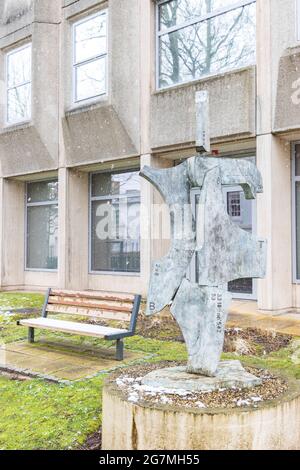 Behind New Walk mostra la scultura Clicker di John Atkin. Panca dietro, erba gialla e verde brillante. Leicester IBM ufficio con neve. Foto Stock