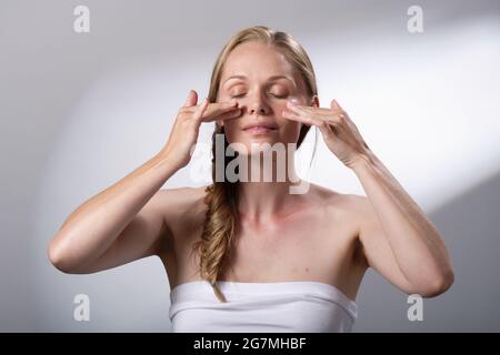 Regime di trattamento di bellezza usando le mani e le dita per massaggiare delicatamente il viso. Calma e relax. Io tempo. Foto Stock