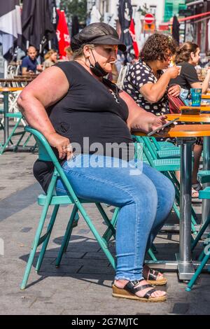 Donna morbilamente obesa al bar terrazza tavolo - Saint Gilles, Bruxelles, Belgio. Foto Stock