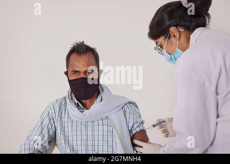 UN UOMO COMUNE SEDUTO E VACCINATO Foto Stock