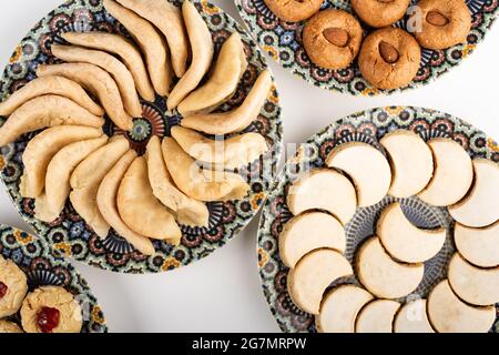 Biscotti tradizionali marocchini fatti a mano in un piatto di ceramica su bianco Foto Stock