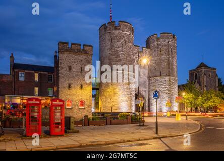 Westgate Towers medievale gateway due telefoni rossi Westgate di notte Canterbury Kent Inghilterra GB Europa Foto Stock