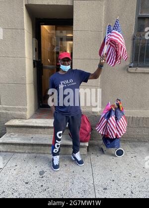 Man vende bandiere americane il 4 luglio, Independence Day, sulla 34th Street vicino al Fiume Est, dove l'annuale fuochi d'artificio Macy's 4 luglio si terrà più tardi in serata. NEW YORK Foto Stock