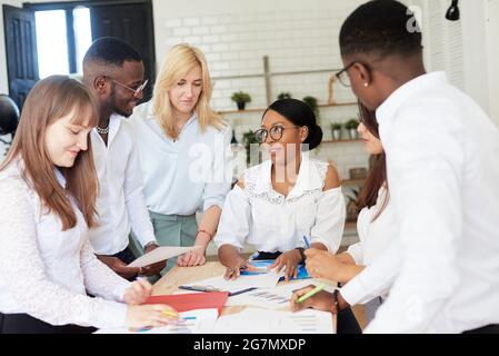 Felice squadra sorridente di multinazionali ridere, sorridere e gioire per la vittoria, il contratto firmato o l'accordo firmato. Foto Stock
