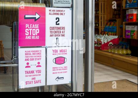 Windsor, Berkshire, Regno Unito. 14 luglio 2021. Un Covid-19 misura l'avviso in una finestra di un cafe a Windsor. 1200 scienziati e medici si sono espressi contro la rimozione di distanza sociale e l'obbligo legale di indossare maschere facciali, mentre in negozi da lunedì 19 luglio 2021, in quanto temono che questo aumenterà il numero crescente di casi Covid-19 ancora di più. Credito: Maureen McLean/Alamy Foto Stock