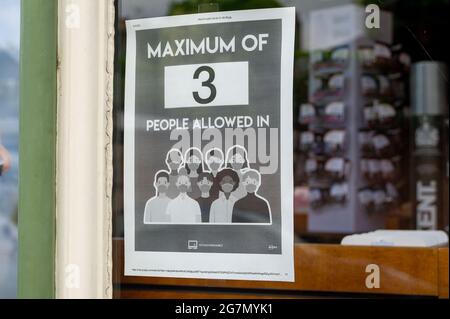 Windsor, Berkshire, Regno Unito. 14 luglio 2021. Un Covid-19 misura l'avviso in una finestra di farmacia in Windsor. 1200 scienziati e medici si sono espressi contro la rimozione di distanza sociale e l'obbligo legale di indossare maschere facciali, mentre in negozi da lunedì 19 luglio 2021, in quanto temono che questo aumenterà il numero crescente di casi Covid-19 ancora di più. Credito: Maureen McLean/Alamy Foto Stock