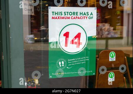 Windsor, Berkshire, Regno Unito. 14 luglio 2021. Un avviso di capacità massima del Covid-19 in una vetrina a Windsor. 1200 scienziati e medici si sono espressi contro la rimozione di distanza sociale e l'obbligo legale di indossare maschere facciali, mentre in negozi da lunedì 19 luglio 2021, in quanto temono che questo aumenterà il numero crescente di casi Covid-19 ancora di più. Credito: Maureen McLean/Alamy Foto Stock