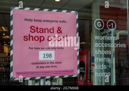 Windsor, Berkshire, Regno Unito. 14 luglio 2021. Un avviso di restrizione per i numeri Covid-19 nella finestra di TK Maxx a Windsor. 1200 scienziati e medici si sono espressi contro la rimozione di distanza sociale e l'obbligo legale di indossare maschere facciali, mentre in negozi da lunedì 19 luglio 2021, in quanto temono che questo aumenterà il numero crescente di casi Covid-19 ancora di più. Credito: Maureen McLean/Alamy Foto Stock