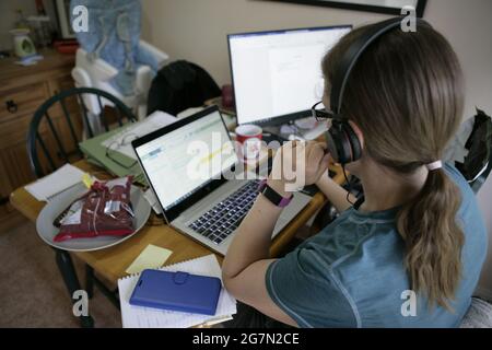 La madre lavoratrice continua a lavorare a distanza da casa durante la pandemia di Coronavirus del 2021, Inghilterra, Regno Unito, luglio 2021 Foto Stock