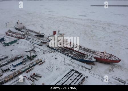 Arkhangelsk, Russia - 26 dicembre 2020: Paesaggio invernale del fiume e ormeggiate navi a riva. Foto Stock