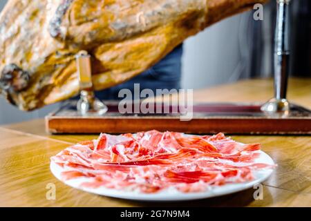 Appetitose fette di prosciutto iberico in primo piano. Piatto di prosciutto iberico alimentato con Acorn prosciutto iberico. PATA negra, spettacolare visione del prosciutto a fette. Tipico centro benessere Foto Stock