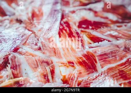Appetitose fette di prosciutto iberico in primo piano. Piatto di prosciutto iberico alimentato con Acorn prosciutto iberico. PATA negra, spettacolare visione del prosciutto a fette. Tipico centro benessere Foto Stock