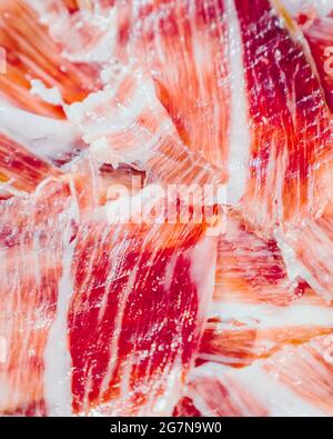 Appetitose fette di prosciutto iberico in primo piano. Piatto di prosciutto iberico alimentato con Acorn prosciutto iberico. PATA negra, spettacolare visione del prosciutto a fette. Tipico centro benessere Foto Stock